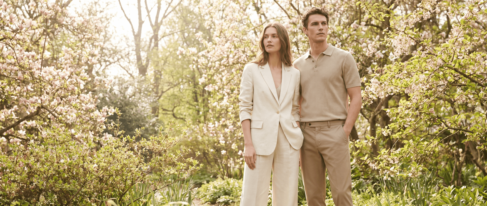 Two people standing in a garden with blooming trees